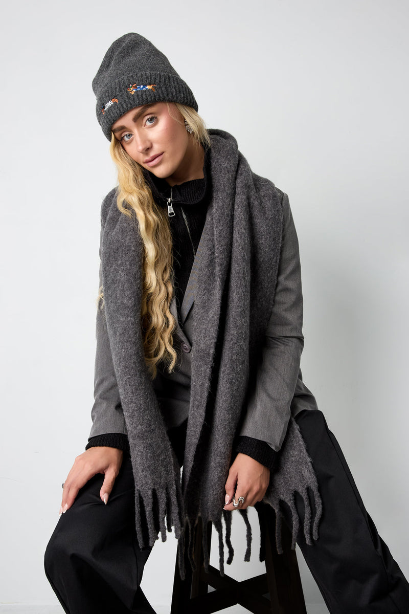 Model trägt den Vanja Schal in Dunkelgrau mit grauer Beanie und dunkler Jacke